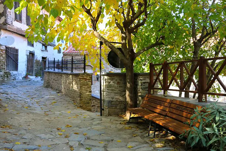 Gasse mit Pflastersteinen und einer Parkbank