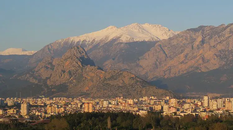 Sonne und grüne Palmen an der Küste und Schnee auf den Berggipfeln, das Wetter in Antalya im Dezember