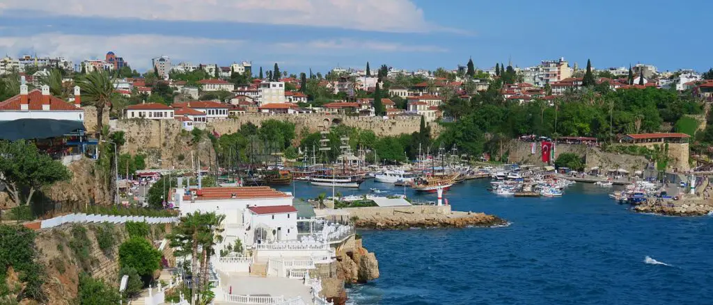 Das Wetter in der Altstadt von Antalya in der Türkei ist im April sonnig und warm. Das Bild zeigt den Hafen und die grünen Palmen am Meer.