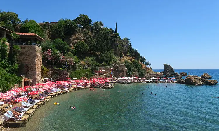 Sonnige Wetter, Liegestühle und das türkisblaue Meer am Mermerli Strand in Antalya.