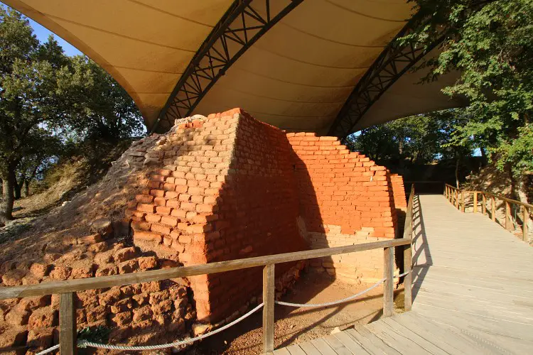 Burgmauern aus roten Ziegelsteinen, von einem weißen Dach geschützt. 