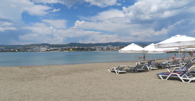 Strandliegen, Sonnenschirme und Sandstrand