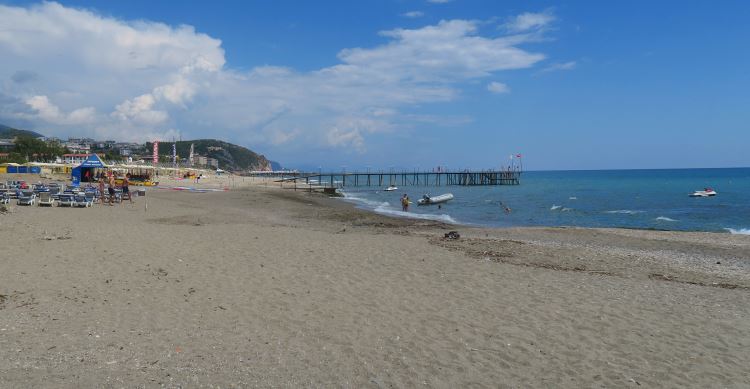 Sandstrand, Meer, Liegestühle und Sonnenschirme mit Badegästen