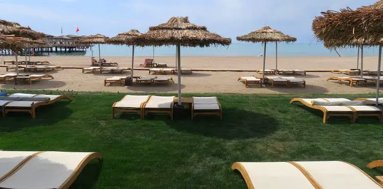 Sonnenliegen am Strand und eine Wiese