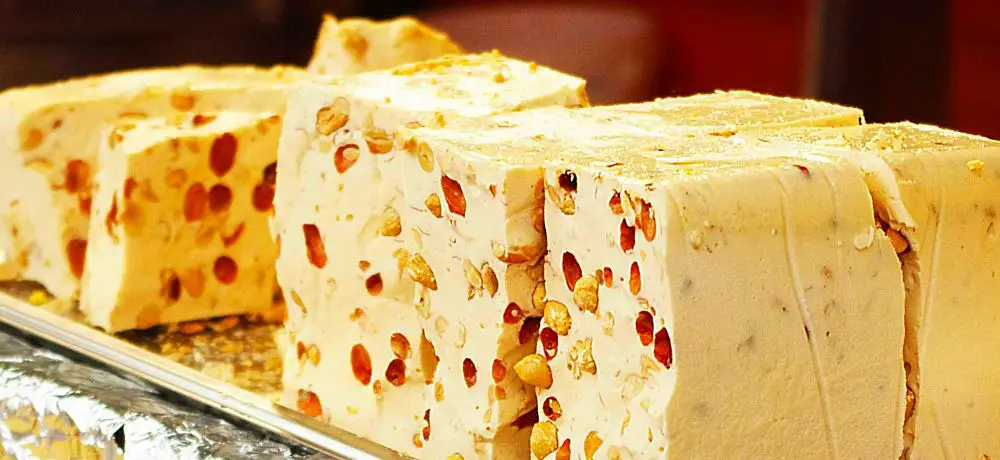 Helva "Türkischer Honig" bzw. "Weißer Nougat" mit Nusstückchen in einer Auslage