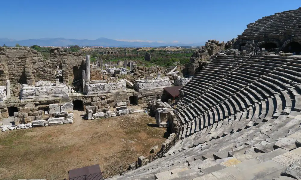 Blick von den Sitzplätzen des Theaters auf die Bühne und die dahinterliegenden Ruinen. 