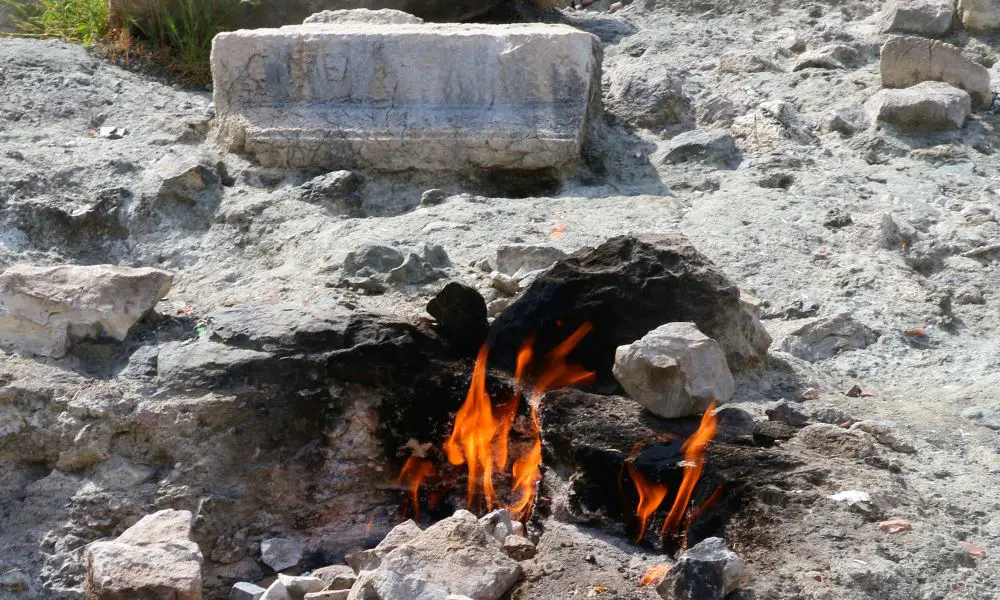 Aus dem Boden austretenden Flammen mit Ruinen im Hintergrund