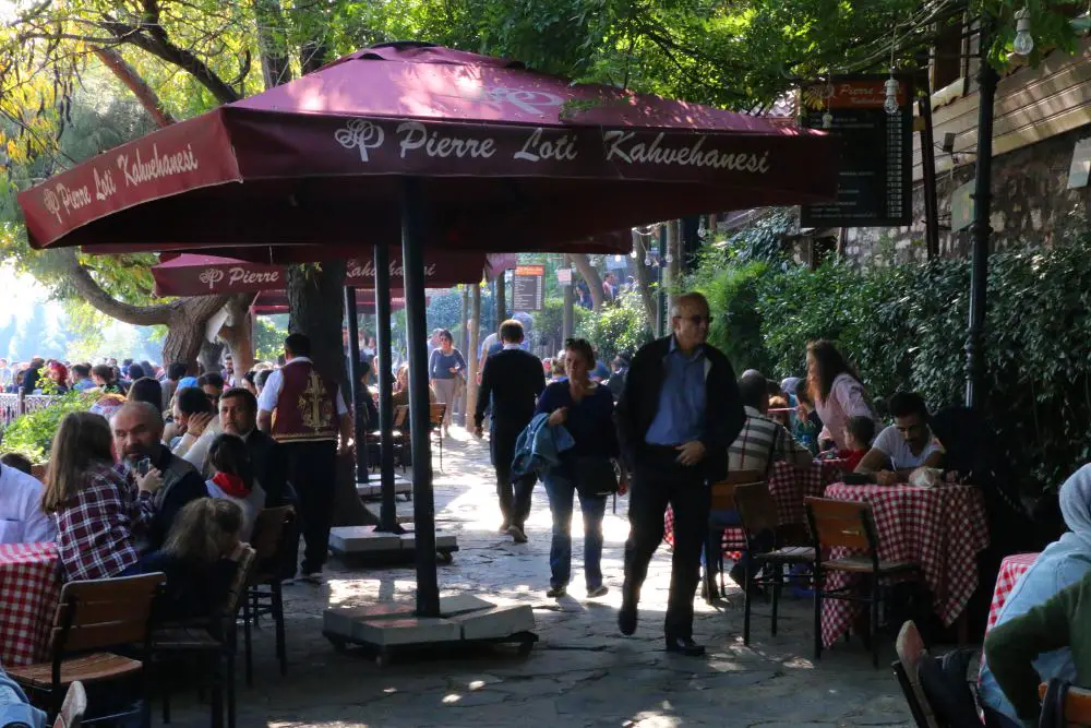 Eines der ersten Cafes nach der Seilbahn auf dem Pierre Loti Hügel mit Sonnenschirmen und Tischen zum Sitzen.