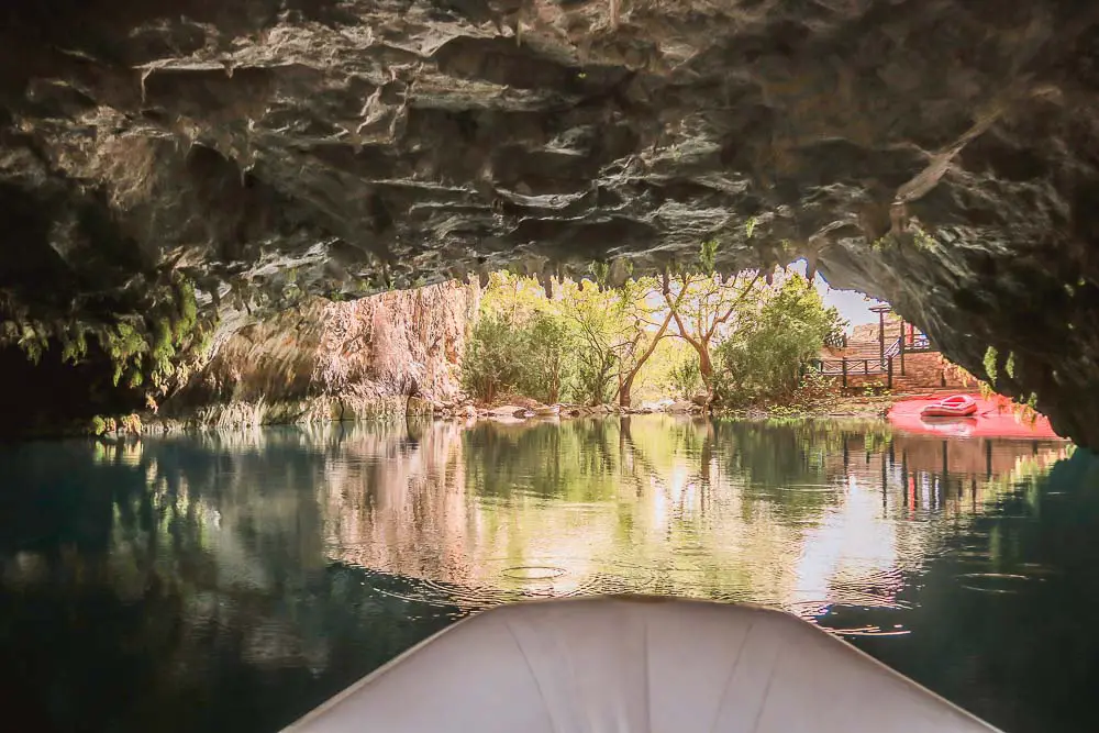 Eingang der Altinbesik Höhle von einem Schlauchboot vom Inneren der Höhle aus gesehen auf einem See. 