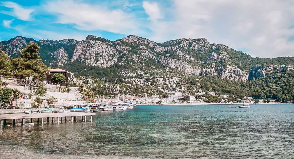 Strand, Pier, Meer und Hotels mit den Bergen im Hintergrund