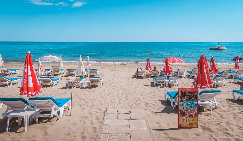 Liegestühle und Sonnenschirme am Orange Beach in Alanya in der Türkei. 