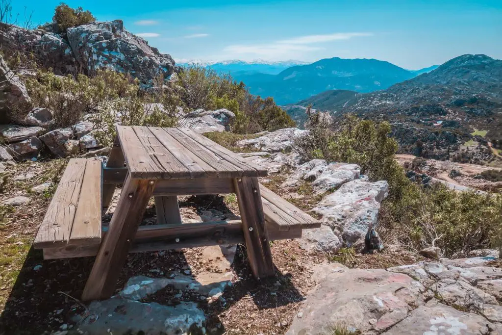 Ein Wandertisch mit zwei Sitzbänken und Ausblick auf die Berge