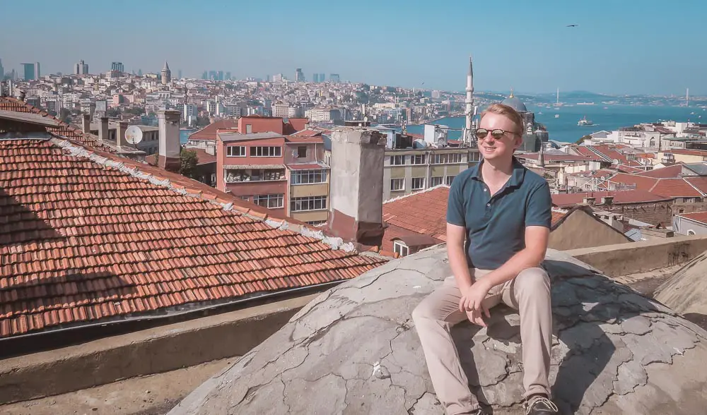 Thomas von TürkeiReiseblog.de sitzt auf einem Dach in Istanbul mit Ausblick auf den Bosporus.