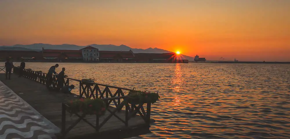 Sonnenuntergang am Konak Pier mit einem orangefarbenen Himmel und Anglern an der Promenade