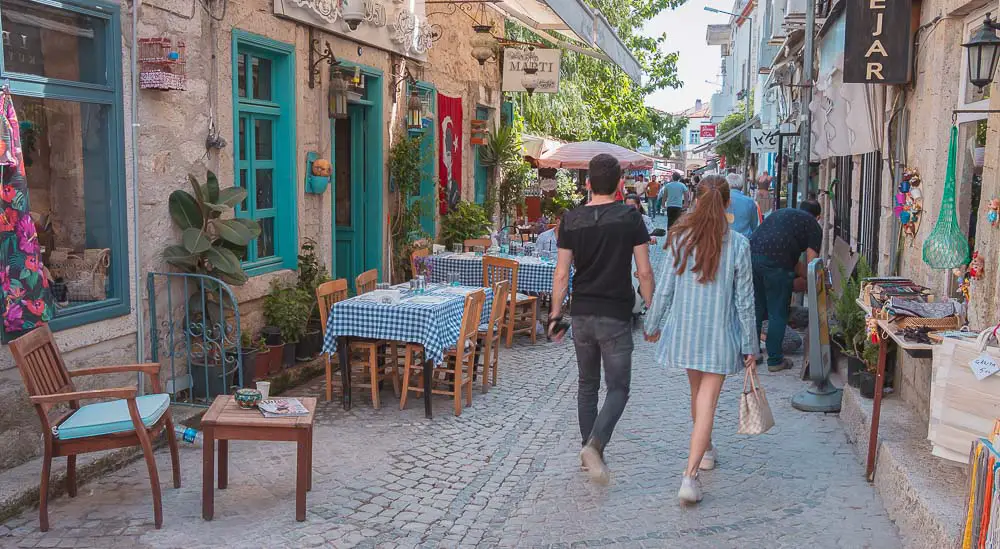 Menschen in den Straßen von Alacati, ein Restaurant und Geschäfte