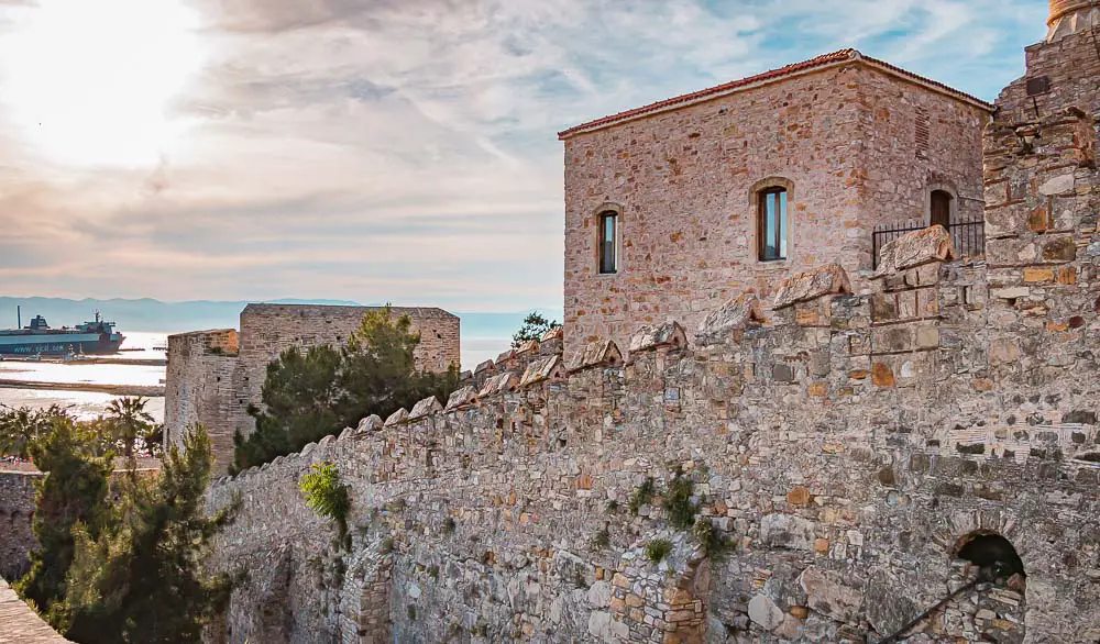 Burg am Hafen von Cesme mit dem Burgmauern, dem Hafen, dem Meer und Schiffen im Hintergrund