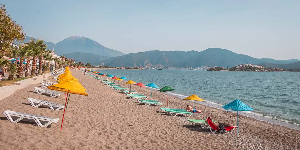 Sonnenliegen am Calis Beach Sandstrand mit Blick in Richtung Fethiye