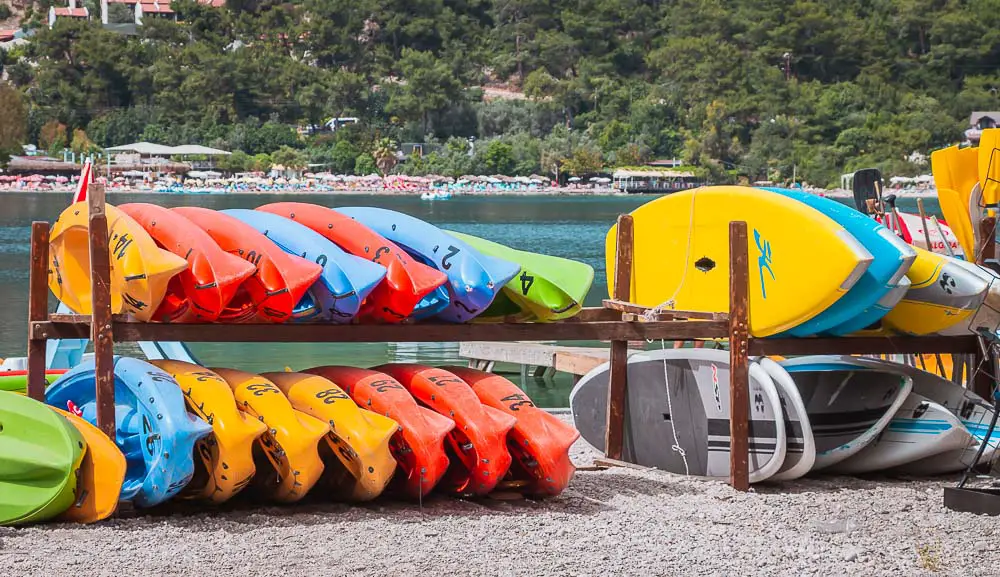 Aufgestapelte Surfbretter und Kajaks an der Blauen Lagune in Ölüdeniz