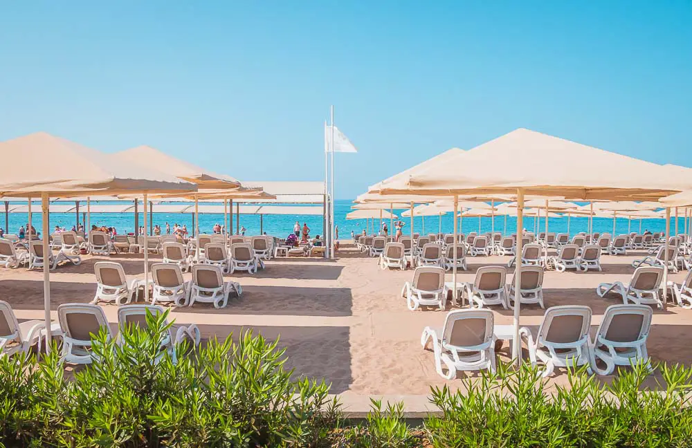 Sonnenliegen, Sonnenschirme und das Meer an einem Sandstrand