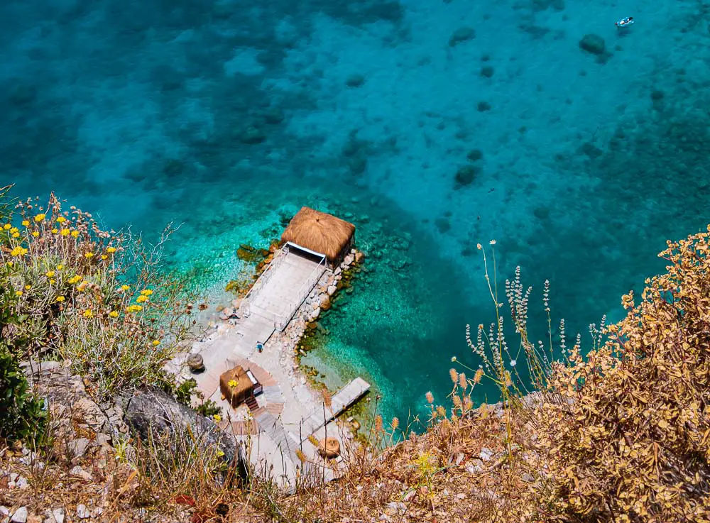 Versteckte Badestelle mit einem Pier und türkisblauen Meer