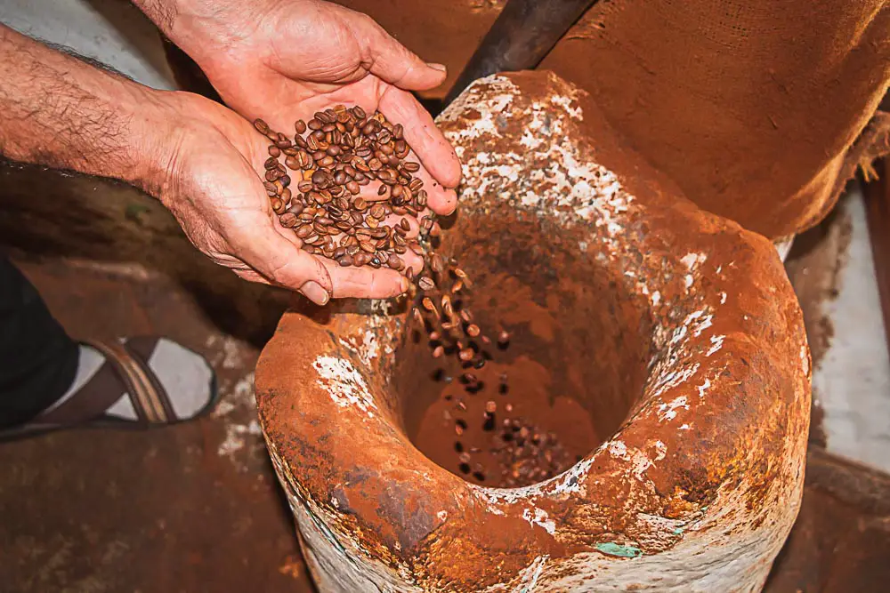 Frisch gerösteter Kaffee kommt in den Mörser